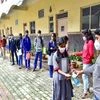 A worker sanitises the hands of a student before she appears for the SSLC exam, during Covid-induced lockdown in Bengaluru (Photo: PTI)