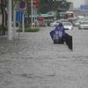 A resident wearing a rain cover stands on a flooded road in Zhengzhou, Henan province, China. (Photo: Reuters)