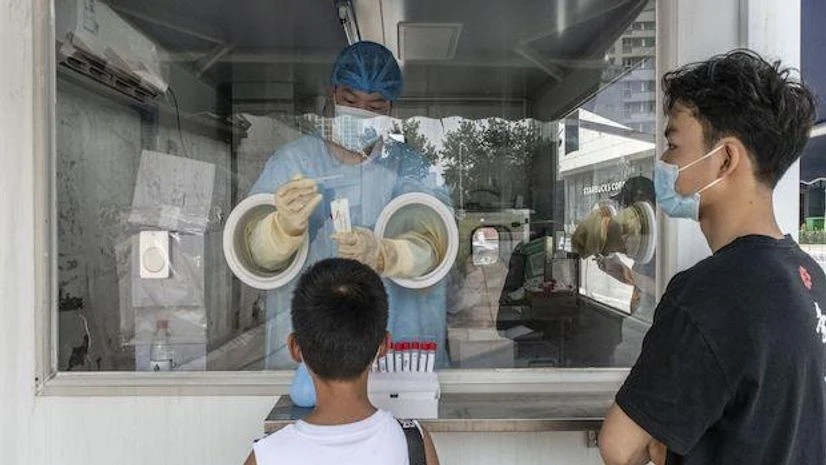A health worker takes a swab sample at a pop-up Covid-19 testing station in the Sanlitun area of Beijing, China, on Thursday, Aug. 5, 2021. China imposed new travel and movement restrictions amid a delta-driven outbreak that's grown to over 500 sympt A health worker takes a swab sample at a pop-up Covid-19 testing station in the Sanlitun area of Beijing, China, on Thursday, Aug. 5, 2021. China imposed new travel and movement restrictions amid a delta-driven outbreak that’s grown to over 500 sympt