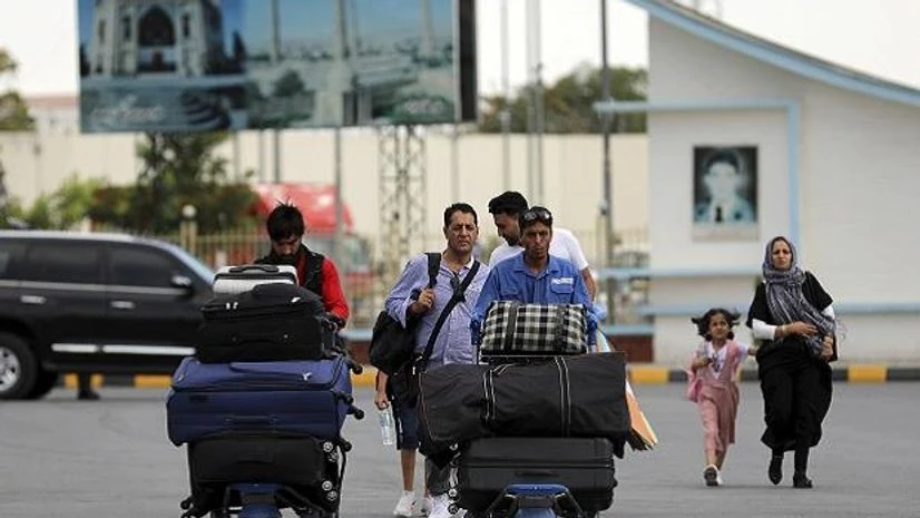 Passengers walk to the departures terminal of Hamid Karzai International Airport in Kabul, Afghanistan, Saturday, Aug. 14, 2021. Passengers walk to the departures terminal of Hamid Karzai International Airport in Kabul, Afghanistan, Saturday, Aug. 14, 2021.