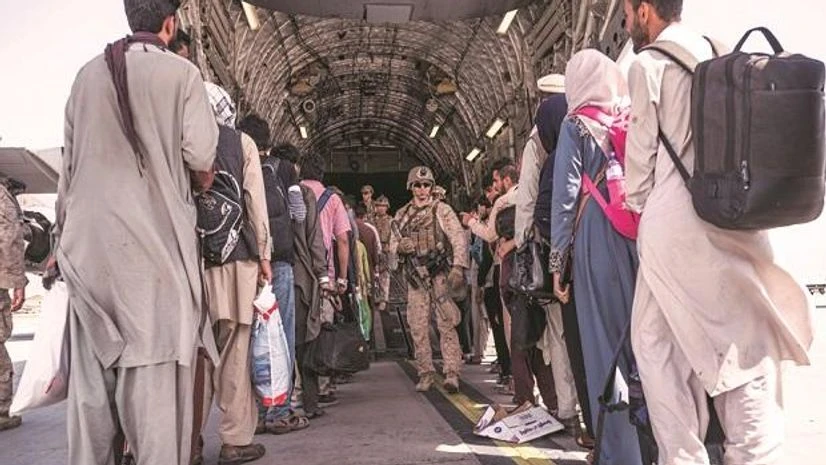 Afghanistan, Taliban US Airmen and Marines personnel guide qualified evacuees aboard a US Air Force C-17 Globemaster III at Hamid Karzai International Airport. (Photo: Reuters)
