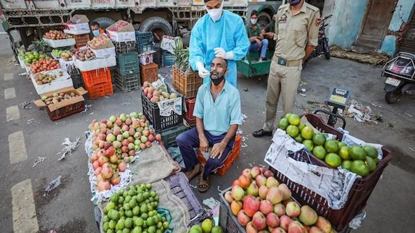 A health worker testing for Covid-19 collects the swab sample of a shopkeeper at a vegetable market in Jammu on September 15, 2021. (PTI Photo) A health worker testing for Covid-19 collects the swab sample of a shopkeeper at a vegetable market in Jammu on September 15, 2021. (PTI Photo)