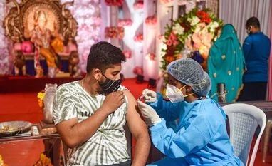 India records 30,570 fresh coronavirus cases, 431 more deaths A health worker gives a visitor at a Ganpati pandal in Mumbai a dose of a coronavirus vaccine on September 15, 2021. (PTI photo)