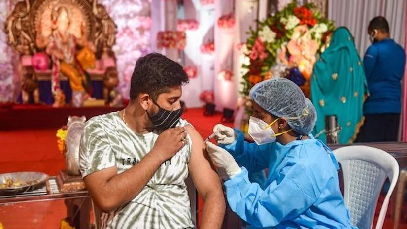 A health worker gives a visitor at a Ganpati pandal in Mumbai a dose of a coronavirus vaccine on September 15, 2021. (PTI photo) A health worker gives a visitor at a Ganpati pandal in Mumbai a dose of a coronavirus vaccine on September 15, 2021. (PTI photo)