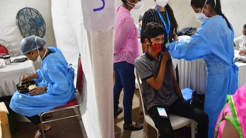 A health worker gives a visitor a Covid-19 vaccine shot at a health centre at the Parel Railway Workshop, in Mumbai on September 24, 2021. (PTI Photo) A health worker gives a visitor a Covid-19 vaccine shot at a health centre at the Parel Railway Workshop, in Mumbai on September 24, 2021. (PTI Photo)