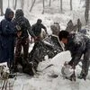 Policemen with people from nomadic community who were stuck in heavy winds and snowfall at higher reaches of Nagbal Yousmarg