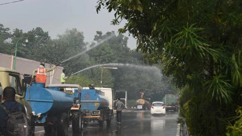 delhi pollution Workers spray water to curb air pollution, as a thick layer of smog engulfs the national capital following Diwali celebrations, in New Delhi (Photo: PTI)