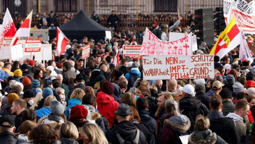 covid protests Demonstrators hold flags and placards as they gather to protest against the coronavirus disease measures in Vienna, Austria. The placard reads: 'For the truth, no to mandatory vaccination, protect our rights.' (Photo: Reuters)