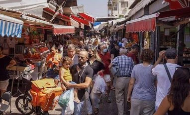 In Israel, Omicron variant drives confusing policy amid 4th Covid jab Shoppers pass between stalls in Carmel Market in Tel Aviv, Israel