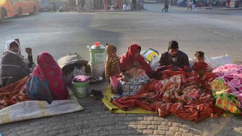delhi winter Homeless people wearing woollen clothes bask in the sun on a cold winter morning, in New Delhi (Photo: PTI)