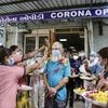 Prafulbhai Dave is greeted by health workers at the government civil hospital in Ahmedabad on December 27, 2021 after recovering from a coronavirus infection. (PTI Photo)