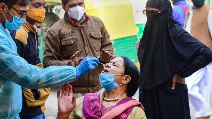 Omicron A health official takes swab sample of a person on a street for COVID-19 test, amid concern over rising Omicron cases, in New Delhi (Photo: PTI)