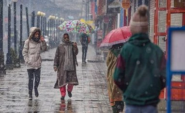 Kashmir receives fresh spell of snowfall, flight services suspended People walk a footpath during the season's first snowfall, in Srinagar (Photo: PTI)