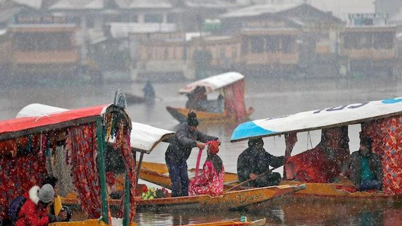 Jammu and Kashmir, cold Tourists travel in boats on the waters of Dal Lake during a snowfall, in Srinagar (Photo: Reuters)