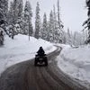 People ride on a snowmobile on a snow-covered road in Gulmarg (Photo: Reuters)