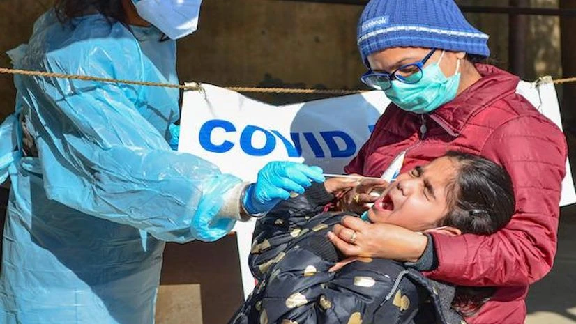 A healthcare worker testing for Covid-19 collects the swab sample of a child in Gurugram, Haryana, January 29, 2022. (PTI Photo) A healthcare worker testing for Covid-19 collects the swab sample of a child in Gurugram, Haryana, January 29, 2022. (PTI Photo)