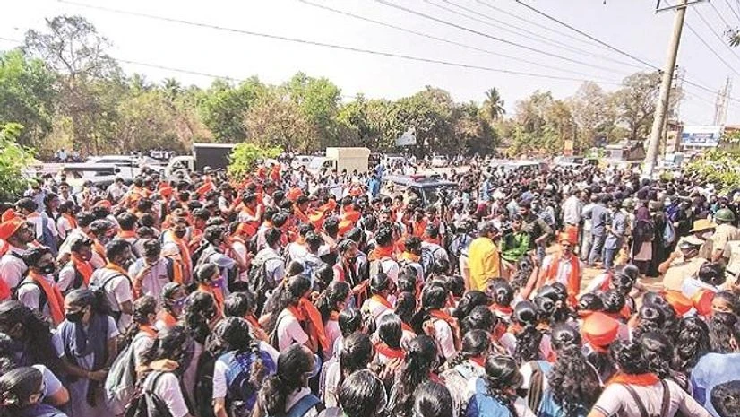 Hijab row, Karnataka Hijab row Students wearing saffron robes and hijab stage a protest outside the Mahatma Gandhi Memorial College campus in Udupi district on Tuesday. PTI photo