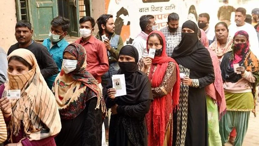 UP elections, Uttar Pradesh People wait in queues at a polling station to cast their votes for the fourth phase of UP Assembly polls, in Lucknow (Photo: PTI)