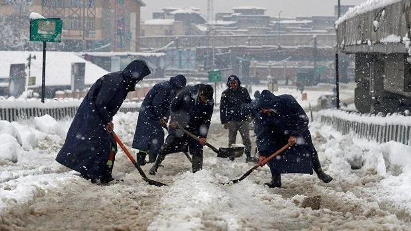 Srinagar snowfall Municipal workers use shovels to remove snow from road during snowfall in Srinagar (Photo: Reuters)