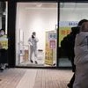 Pedestrians walk past a Covid-19 polymerase chain reaction (PCR) testing site in the Shinjuku district of Tokyo on Friday, Feb. 25, 2022. (Photo: Bloomberg)