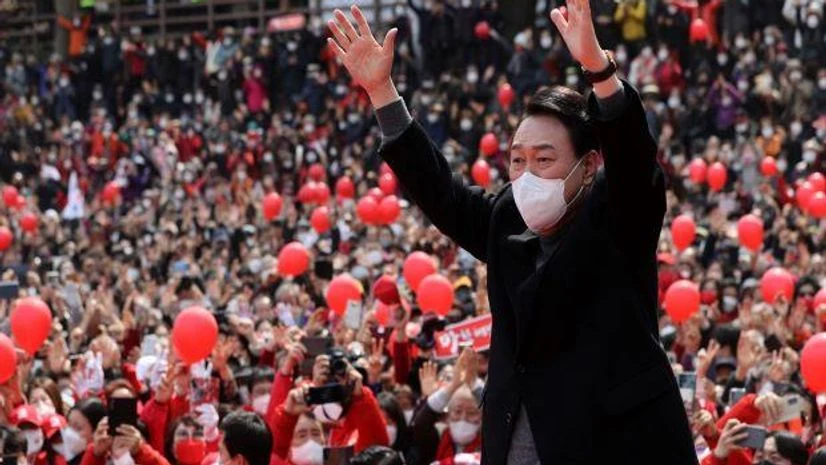 south korea Yoon Suk Yeol, the presidential candidate of the main opposition People Power Party, raises his hands during a presidential election campaign in Busan, South Korea. (Yonhap via AP)