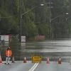A emergency worker stands by a flooded road at Windsor on the outskirts of Sydney, Australia, Thursday, March 3, 2022.