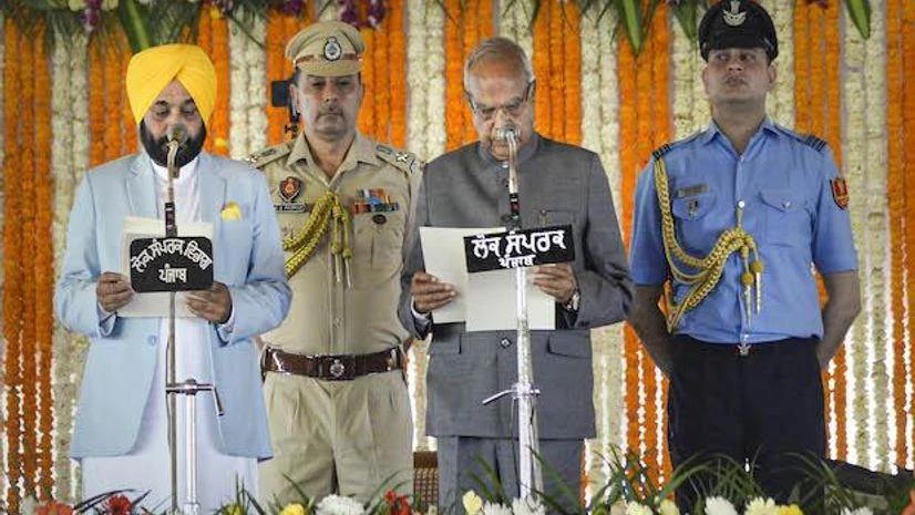 Bhagwant Mann Punjab Governor Banwarilal Purohit with AAP leader Bhagwant Mann as he takes oath as Punjab Chief Minister, at Khatkar Kalan the birthplace of Shaheed Bhagat Singh, in Nawanshahr near Jalandhar (Photo: PTI)