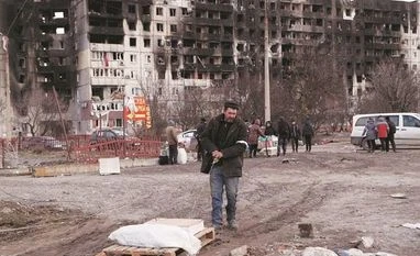 Ukraine defiant as key port city Mariupol teeters on brink Local residents stand in front of a residential building which was damaged in the besieged southern port city of Mariupol | Photo: Reuters