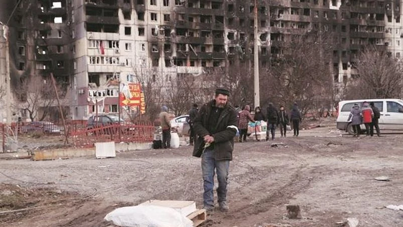 Local residents stand in front of a residential building which was damaged in the besieged southern port city of Mariupol | Photo: Reuters Local residents stand in front of a residential building which was damaged in the besieged southern port city of Mariupol | Photo: Reuters