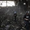 Journalists walk inside a destroyed warehouse for storing food, after an attack from Russia twelve days ago in Brovary, on the outskirts of Kyiv, Ukraine. (AP Photo/Rodrigo Abd)