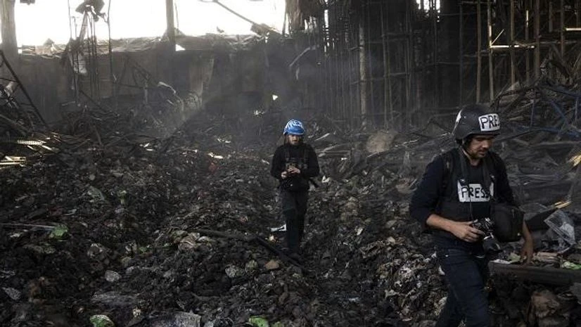 ukraine russia Journalists walk inside a destroyed warehouse for storing food, after an attack from Russia twelve days ago in Brovary, on the outskirts of Kyiv, Ukraine. (AP Photo/Rodrigo Abd)