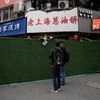 A food vendor holds a QR code for payment over a barrier before the second stage of a two-stage lockdown to curb the spread of the coronavirus disease, in Shanghai (Photo: Reuters)