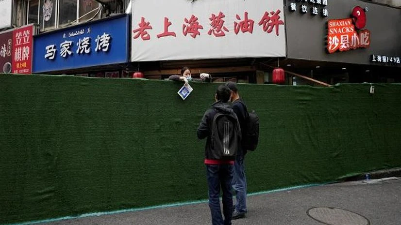 A food vendor holds a QR code for payment over a barrier before the second stage of a two-stage lockdown to curb the spread of the coronavirus disease, in Shanghai (Photo: Reuters) Shanghai