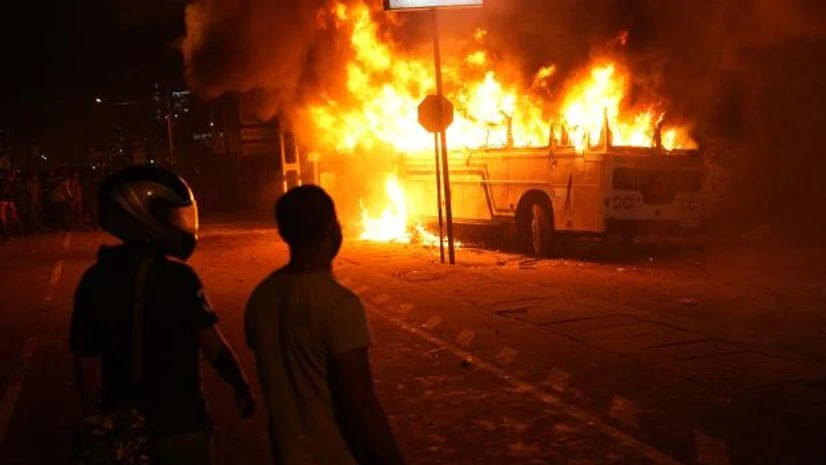 sri lanka crisis Sri Lankans watch after setting a bus on fire during a protest outside Sri Lankan president's private residence on the outskirts of Colombo, Sri Lanka, Friday, April 1, 2022. (AP Photo/Eranga Jayawardena)