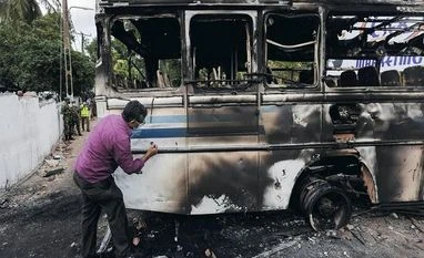 Lanka economic crisis: Ruling coalition urges Prez to form all-party govt Sri Lankan crime scene officer inspects the finger prints on the bus after it was set on fire by demonstrators at the top of the road to Sri Lankan President Gotabaya Rajapaksa's residence during a protest against him (Photo: Reuters)