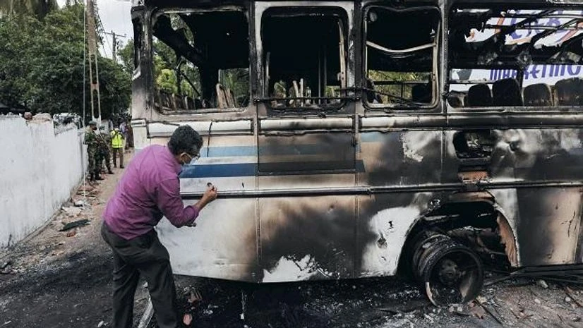 Sri Lankan crime scene officer inspects the finger prints on the bus after it was set on fire by demonstrators at the top of the road to Sri Lankan President Gotabaya Rajapaksa's residence during a protest against him (Photo: Reuters) Sri Lankan crime scene officer inspects the finger prints on the bus after it was set on fire by demonstrators at the top of the road to Sri Lankan President Gotabaya Rajapaksa's residence during a protest against him (Photo: Reuters)