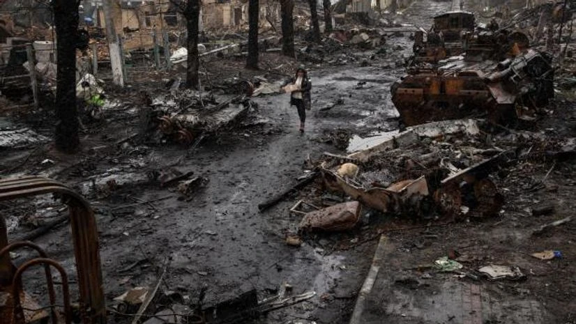 ukraine russia war bucha A woman walks amid destroyed Russian tanks in Bucha, in the outskirts of Kyiv, Ukraine, Sunday, April 3, 2022. (AP Photo/Rodrigo Abd)