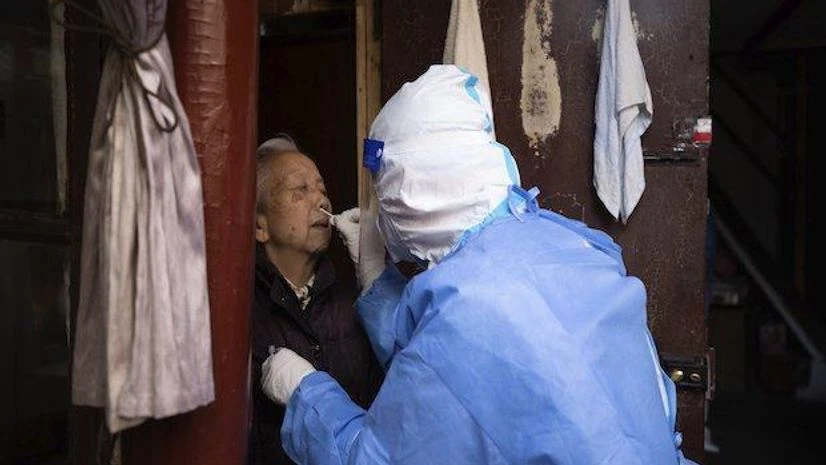 China, Covid In this photo released by Xinhua News Agency, a medical worker conducts antigen testing for an elder resident in Shanghai (Photo via AP/PTI)