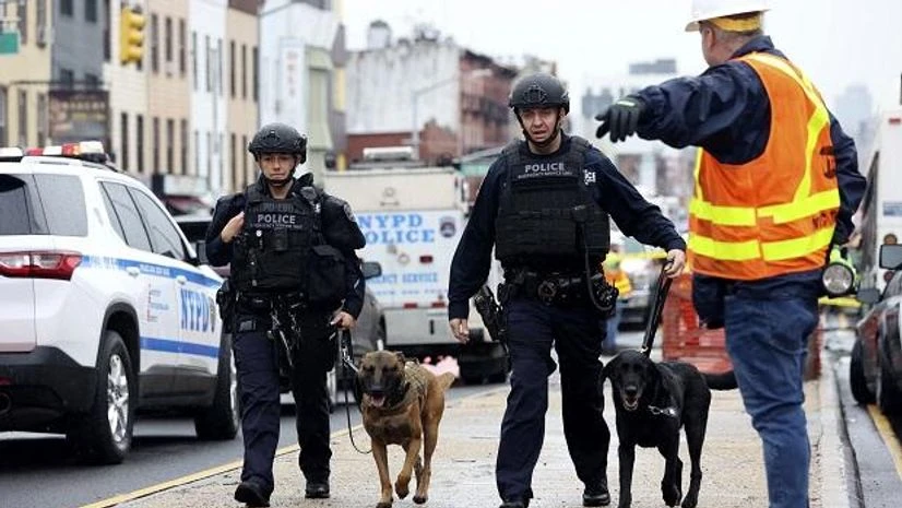 Brooklyn Shooting Officers with bomb-sniffing dogs look over the area after a shooting on a subway train April 12, 2022, in the Brooklyn borough of New York. (AP Photo/Kevin Hagen)