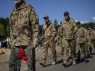 Ukraine, Ukraine soldiers Irpin Territorial Defence and Ukrainian Army soldiers hold flowers to be placed on the graves of comrades fallen during the Russian occupation, at the cemetery of Irpin, on the outskirts of Kyiv, on Sunday, May 1, 2022. (AP Photo/Emilio Morenatti)