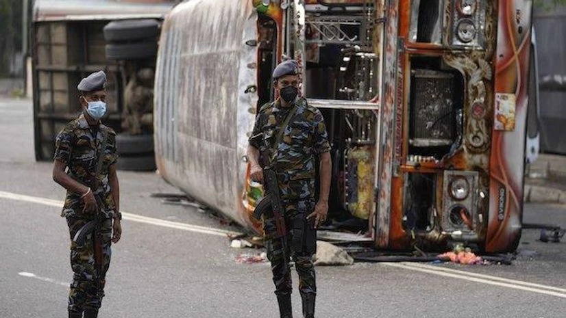 Sri Lanka Sri Lankan soldiers stand guard next to burnt buses a day after clashes between government supporters and anti-government protesters in Colombo (Photo: AP/PTI)