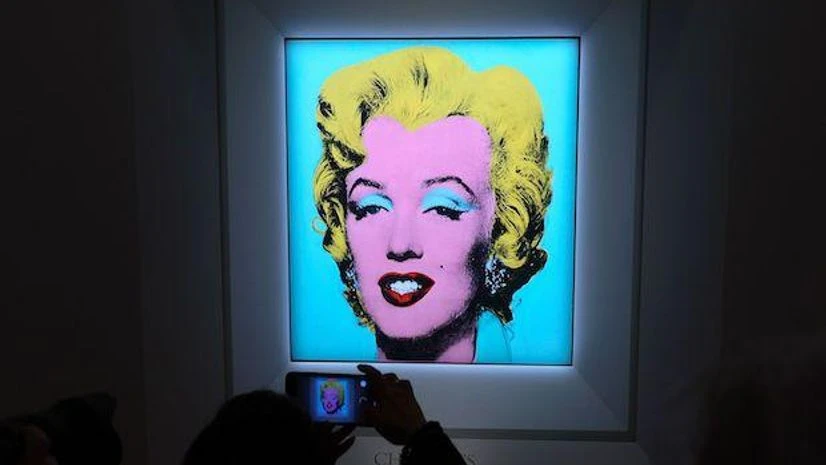 Marilyn Monroe A guest takes a photo during Christie's announcement that they will offer Andy Warhol’s Shot Sage Blue Marilyn painting of Marilyn Monroe at Christie’s on March 21, 2022 in New York City. (Photo: Bloomberg)