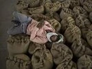 rice, wheat, food A worker rests on top of wheat grain sacks at a wholesale market in the Narela district of New Delhi, India. (Photo: Bloomberg)