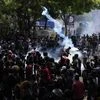 Protestors throw back teargas shells as they rally outside prime minister Ranil Wickremesinghe's office, demanding he resign after president Gotabaya Rajapaksa fled amid economic crisis in Colombo, Sri Lanka (Photo: AP/PTI)