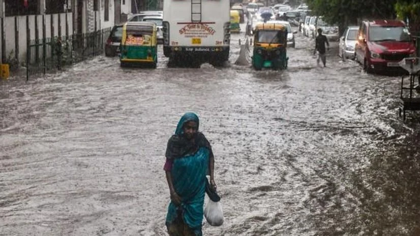 A woman wades through a waterlogged road following incessant monsoon rains, in New Delhi (Photo: PTI) A woman wades through a waterlogged road following incessant monsoon rains, in New Delhi (Photo: PTI)