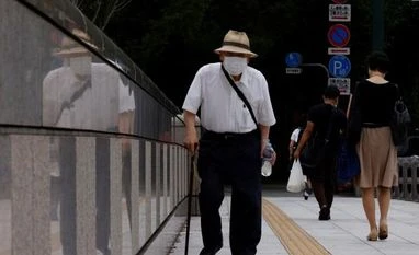 Tokyo's daily Covid cases cross 30,000 for first time in pandemic A man wearing a protective mask walks in Tokyo (Photo: Reuters)