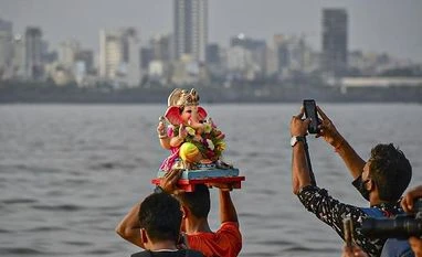 Devotees bid adieu to Lord Ganesh, over 2,100 idols immersed in Mumbai Devotees immerse a Ganesha idol at Dadar Chowpatty, in Mumbai (Photo: PTI)
