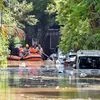 Members of a rescue team row their boat past submerged vehicles following torrential rains in Bengaluru