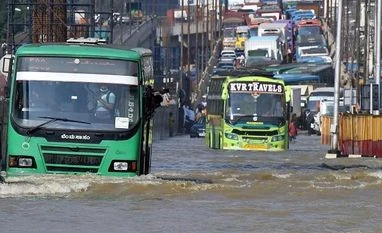 Karnataka IT minister to discuss Bengaluru flood with software companies Traffic moves through a water-logged road following torrential rains in Bengaluru (Photo: Reuters)