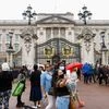 A woman holding flowers takes a selfie outside Buckingham Palace, following the death of Britain's Queen Elizabeth, in London (Photo: Reuters)